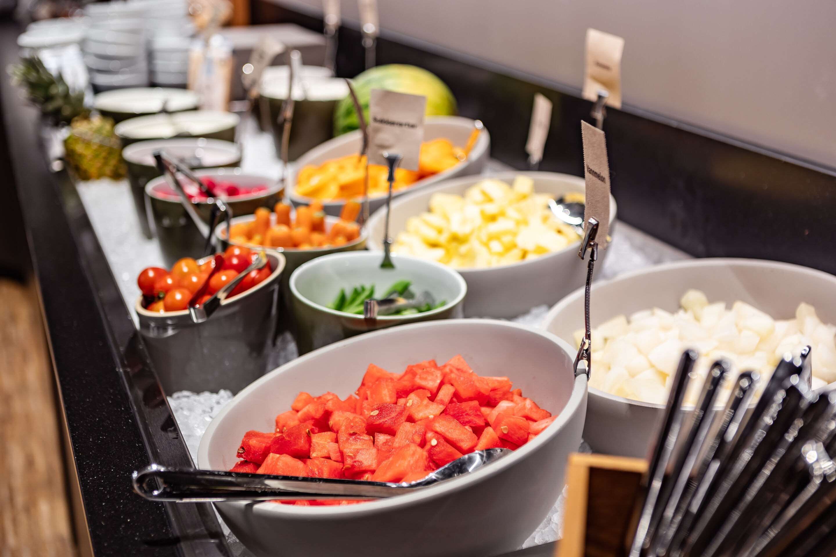 A buffet with various food items including watermelon, pineapple, and other fruits.