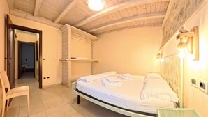 A bedroom with a bed, a chair, a wardrobe, and a mirror.