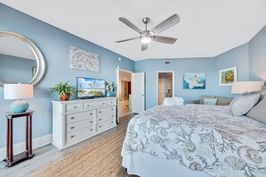 A bedroom with a bed, ceiling fan, dresser, and artwork. - Second floor unit, B206 with AMAZING views! 65”TV! (Orange Beach)