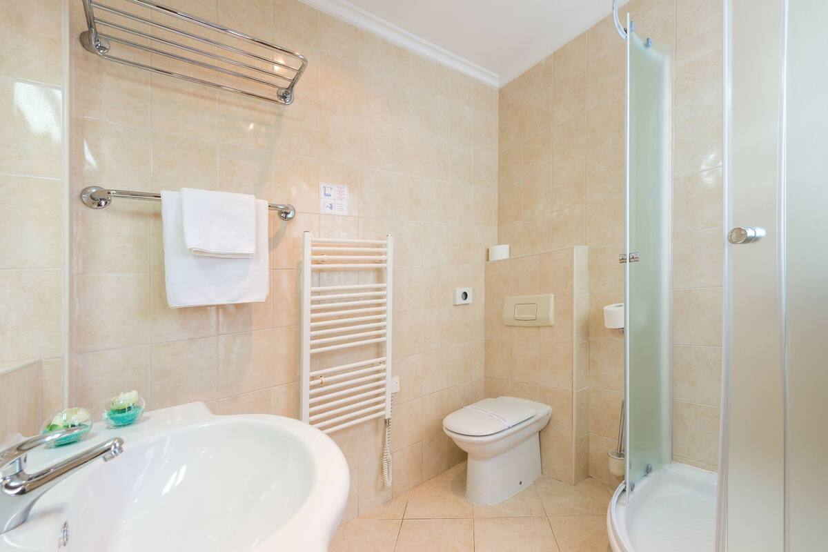 A bathroom with a bathtub, toilet, and shower.
