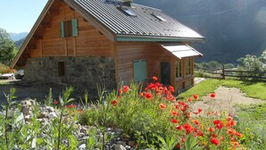 A wooden cabin with a stone foundation, a sloped roof, and a small porch.