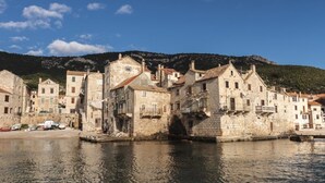 Un pueblo histórico frente al agua, con edificios apretados a la orilla.