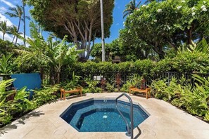 Una piscina rodeada de exuberante vegetación y palmeras.