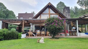 A modern house with a large patio area, outdoor seating, and a stone fireplace. - PEÑA BLANCA EL CIELO RANCHO (AVANDARO)