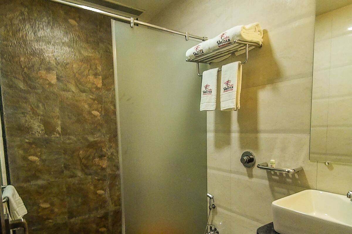 A bathroom with a shower, toilet, and sink.