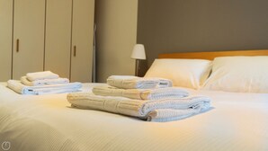 A neatly made bed with folded towels and a lamp on the side. - Baracca 7 A - One Bedroom Apartment, Sleeps 2 (Bologna)