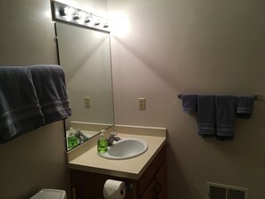 A bathroom with a mirror, sink, and towel rack.