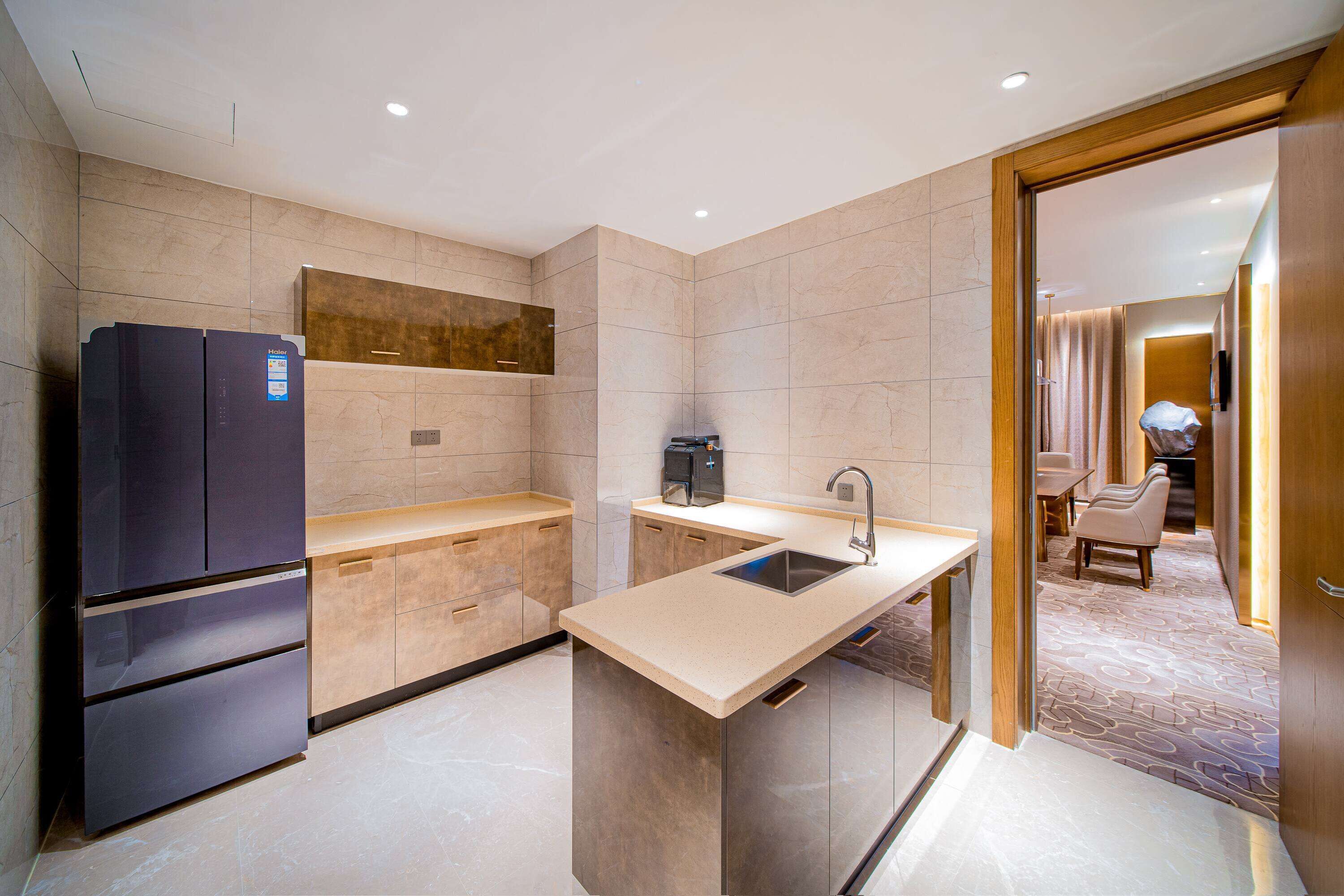 A modern kitchen with a built-in refrigerator, a coffee machine, and a sink.