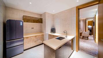 A modern kitchen with a built-in refrigerator, a coffee machine, and a sink.