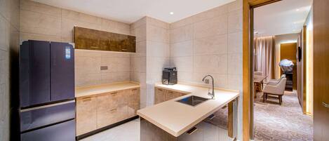 A modern kitchen with a built-in refrigerator, a coffee machine, and a sink.