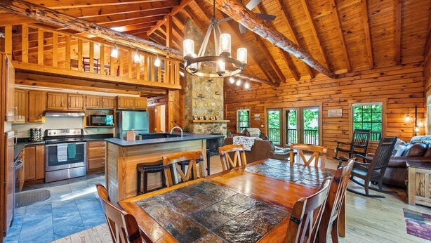 Una cabaña de troncos espaciosa con un amplio comedor, cocina y sala de estar.