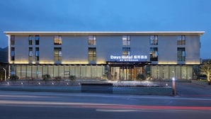 Un hôtel à l’architecture moderne, doté de grandes fenêtres et d’une enseigne indiquant qu’il fait partie de la chaîne Days Hotel by Wyndham.