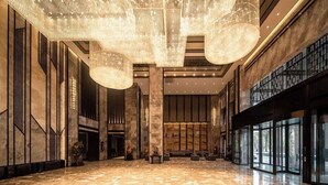 A spacious lobby with a polished marble floor, large hanging chandeliers, and a modern architectural design. - Ramada Plaza by Wyndham Hezhou North (Hezhou)