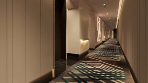 A hotel corridor with a patterned carpet, a reception desk, and a wall-mounted number sign. - Wyndham Garden Wuhan Hankou (Wuhan)