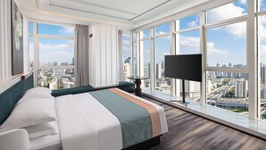 A modern hotel room with a large bed, a TV, and a city view. - Wyndham Garden Wuhan Hankou (Wuhan)