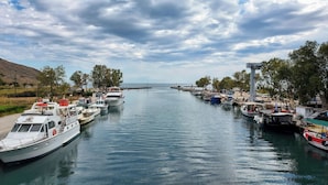 A marina with several boats docked along the waterway, surrounded by trees and a distant view of the sea. - Traditional Cretan stone cottage on the semi-rural outskirts of Kefalas, Vamos (Kefalas)
