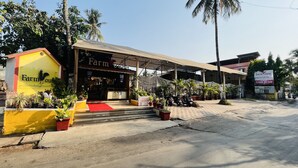 A building with a sign reading "Farmhouse Residence" and a "Valet Parking" sign. - Farmhouse Residency (Vasai)