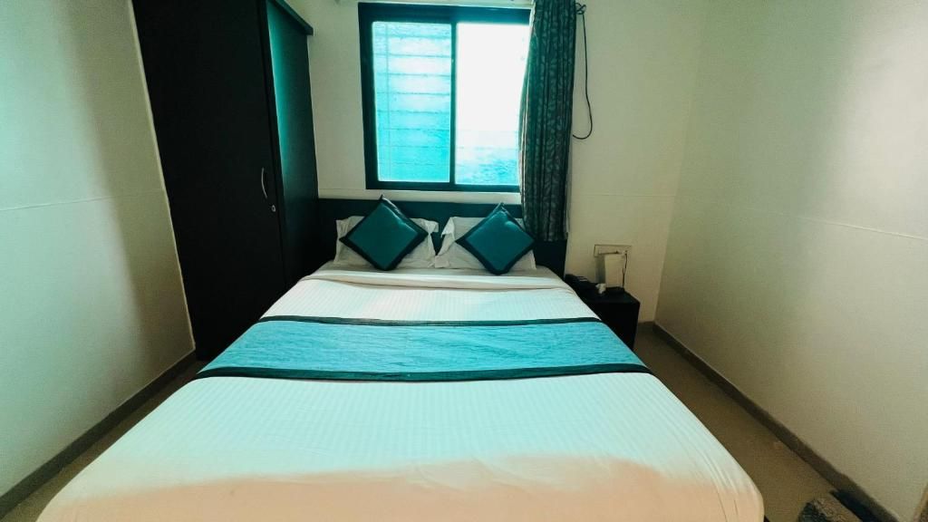 Una habitación de hotel con una cama, una ventana y una puerta.