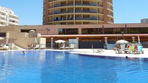 Un grand hôtel à plusieurs étages, avec une piscine située à l’avant.
