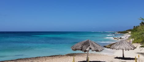 Una playa cerca, sillas reclinables de playa, toallas de playa