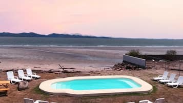 Una piscina al aire libre, sillones reclinables de piscina