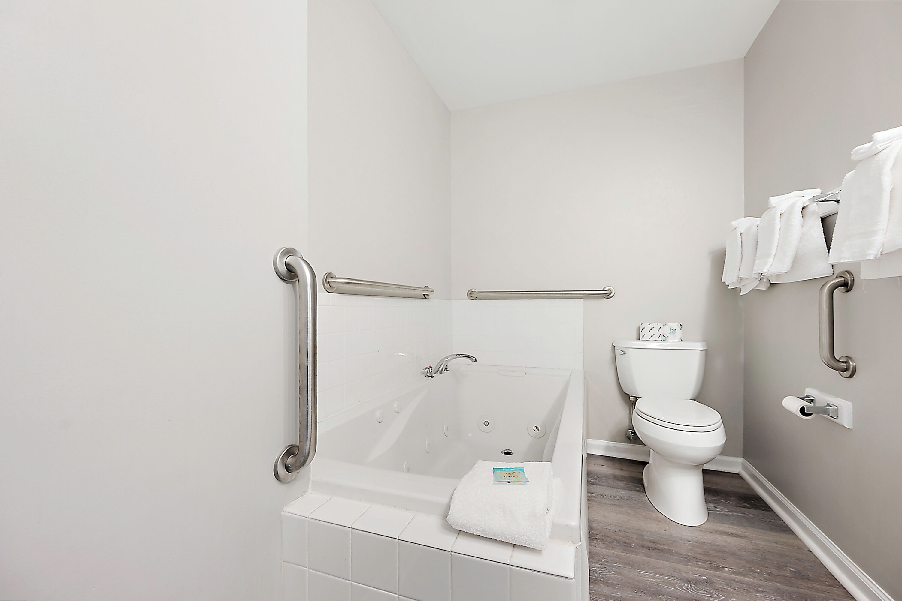 Un bagno con vasca, water e mancorrenti.