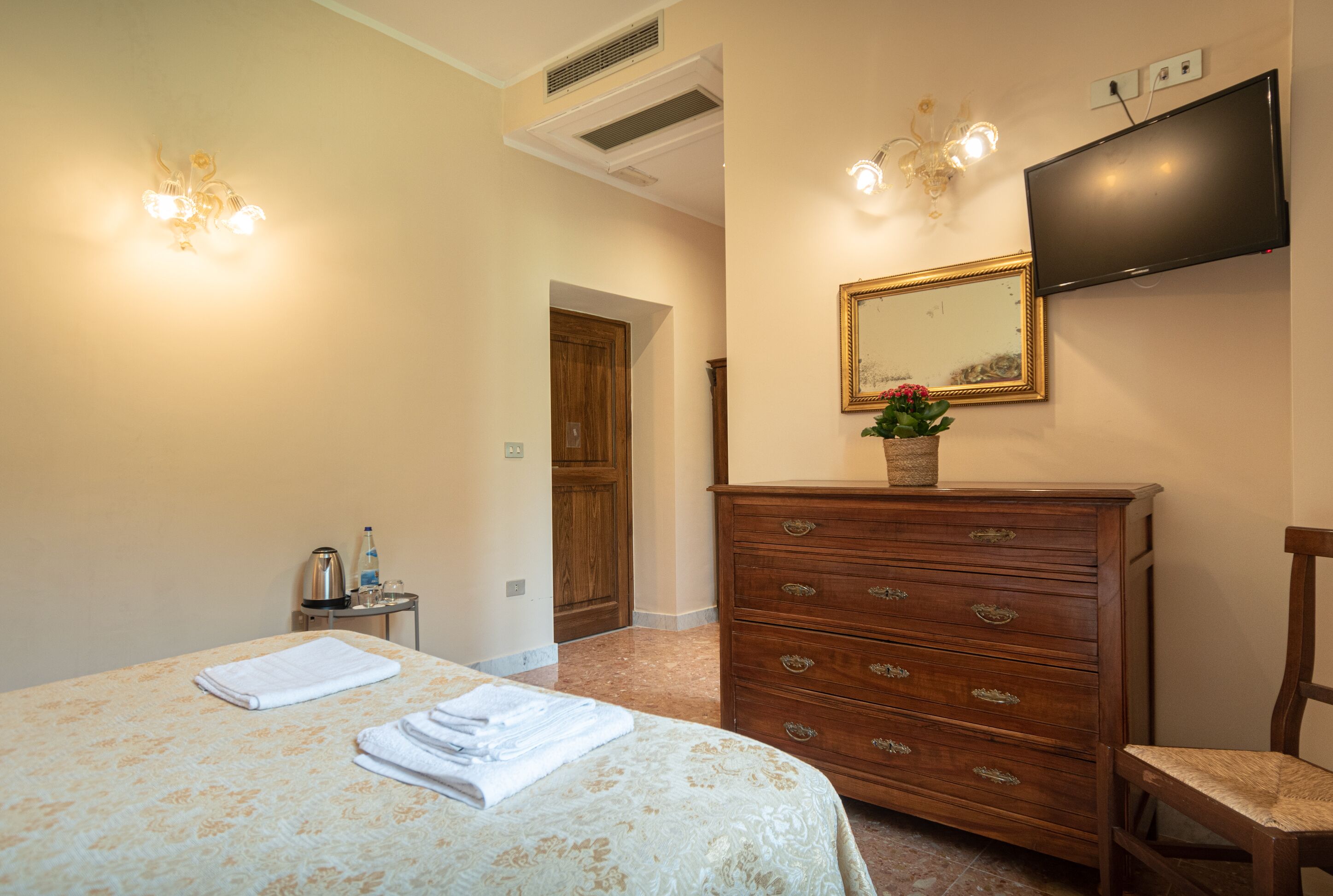 Un dormitorio con cama, cómoda, espejo y televisor.