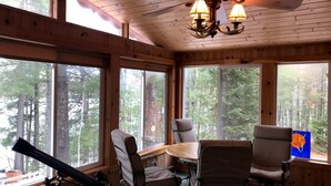 A cabin with large windows, a telescope, and a dining table with chairs. - Spectacular waterfront setting, comfy cabin (Hazelhurst)
