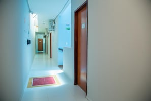 Un pasillo con una puerta marcada con el número 302 y un cartel que indica 'SAIDA'.