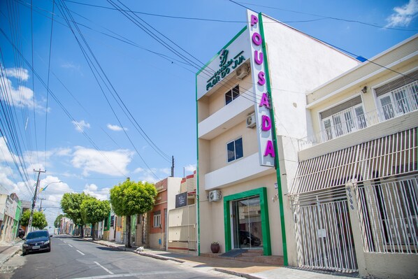 A building with a sign reading "POUDADA" and a green frame around the entrance. - Hotel e Pousada Flor do Jua (Juazeiro do Norte)