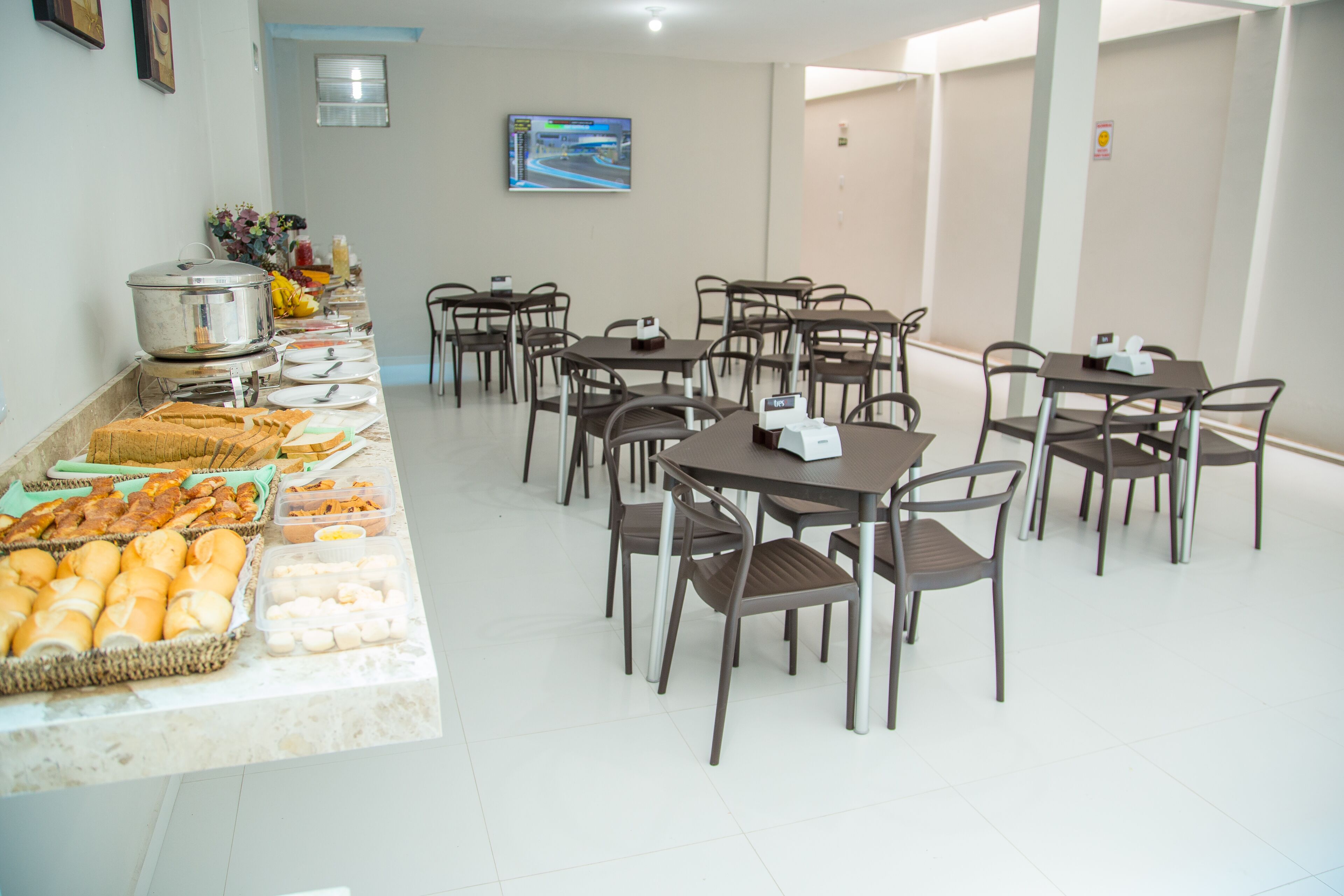 A buffet setup with various food items and a seating area with tables and chairs.