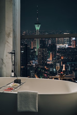 A modern bathroom with a bathtub, a glass of champagne, and a bottle of champagne.