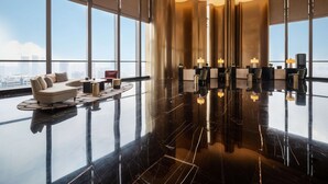 Un amplio vestíbulo con techo alto, ventanas grandes y piso pulido.