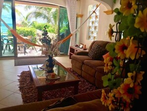 Relax in a serene space with a comfortable sofa and a view of the lush tropical garden.