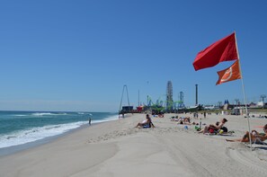 Une plage où des gens se prélassent au soleil et se baignent.