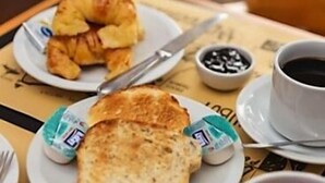 Ein Frühstücksbuffet mit Croissants, Butter, Kaffee und einer Tasse Tee.