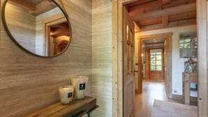 Een houten interieur met een spiegel, kaarsen en een houten bank.
