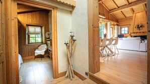 Een houten chalet van binnen, met een eethoek, een keuken en een badkamer.