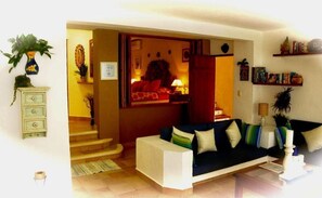Cozy living space with a sofa set and coffee table, featuring a staircase and decorative items on the walls.