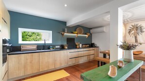 Una cocina moderna con armarios de madera, un ventanal integrado y un banco de madera.