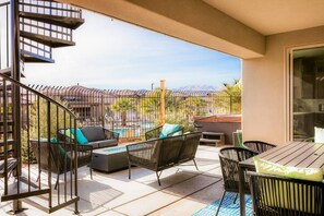 Un balcon avec mobilier d’extérieur, une piscine et une vue sur les montagnes.
