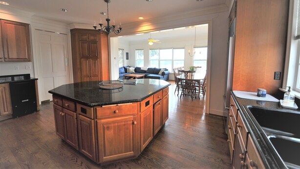A spacious kitchen with wooden cabinets, a large island, and a dining area with a sofa and table. - Beautiful, spacious waterfront home, an easy walk to historic Chestertown (Chestertown)
