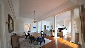A spacious dining area with a wooden table and chairs, a chandelier, and a view into the kitchen. - Beautiful, spacious waterfront home, an easy walk to historic Chestertown (Chestertown)