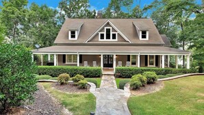 A two-story house with a gabled roof, a covered porch, and a stone pathway leading to the entrance. - Foreststone Fabulous Lake Keowee Waterfront Home (West Union)