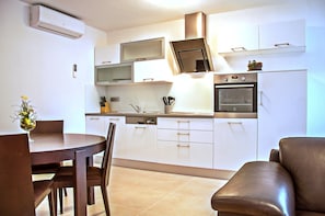 Enjoy cooking in this well-equipped kitchen with an oven and range hood, perfect for preparing meals.