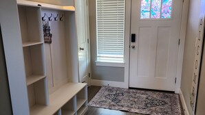 A hallway with a white door, a window with blinds, a wall-mounted light fixture, and a patterned rug. - South Salem - Close to I-5 and Costco, easy Shop and Eat (Salem)