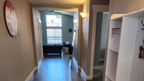 A hallway with wooden flooring, a white shelving unit, and a ceiling fan. - South Salem - Close to I-5 and Costco, easy Shop and Eat (Salem)