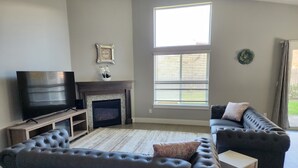 A living room with a fireplace, a television, and two sofas. - South Salem - Close to I-5 and Costco, easy Shop and Eat (Salem)