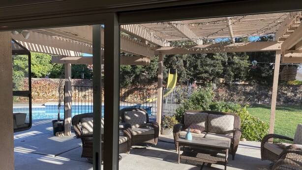 An outdoor patio with wicker furniture, a pool, and a covered area with string lights. - Rare to find house of 5 BR and 4 Bath with big backyard in Fountain Valley.  (Fountain Valley)