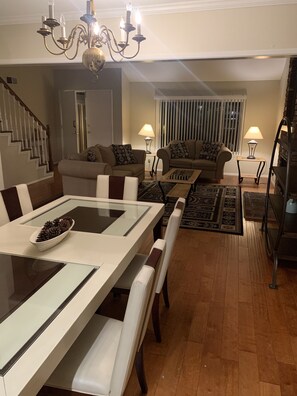 A dining area with a glass-top table, cushioned chairs, and a chandelier. - Rare to find house of 5 BR and 4 Bath with big backyard in Fountain Valley.  (Fountain Valley)